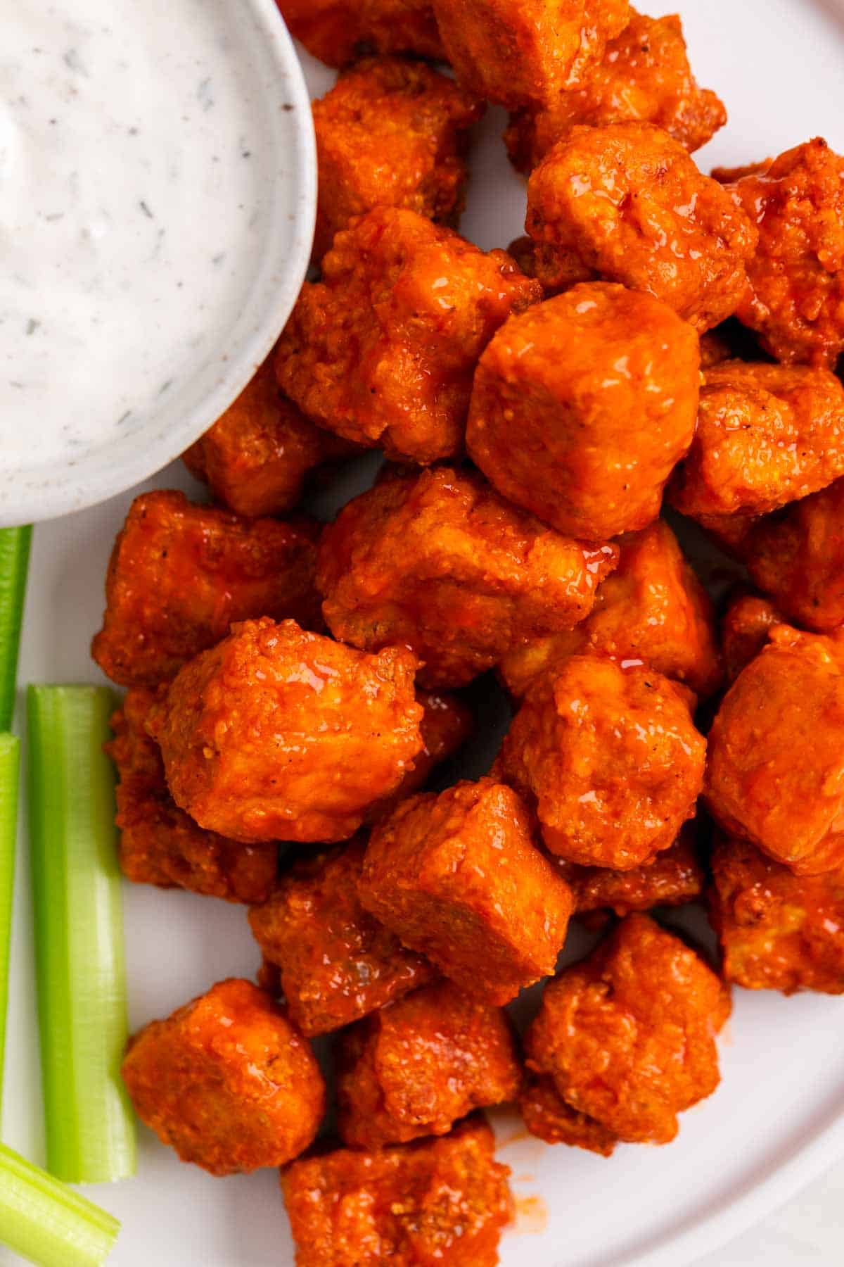 Crispy buffalo tofu served with celery sticks and vegan ranch dressing