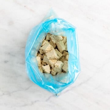 Tofu pieces tossed with olive oil in a freezer bag