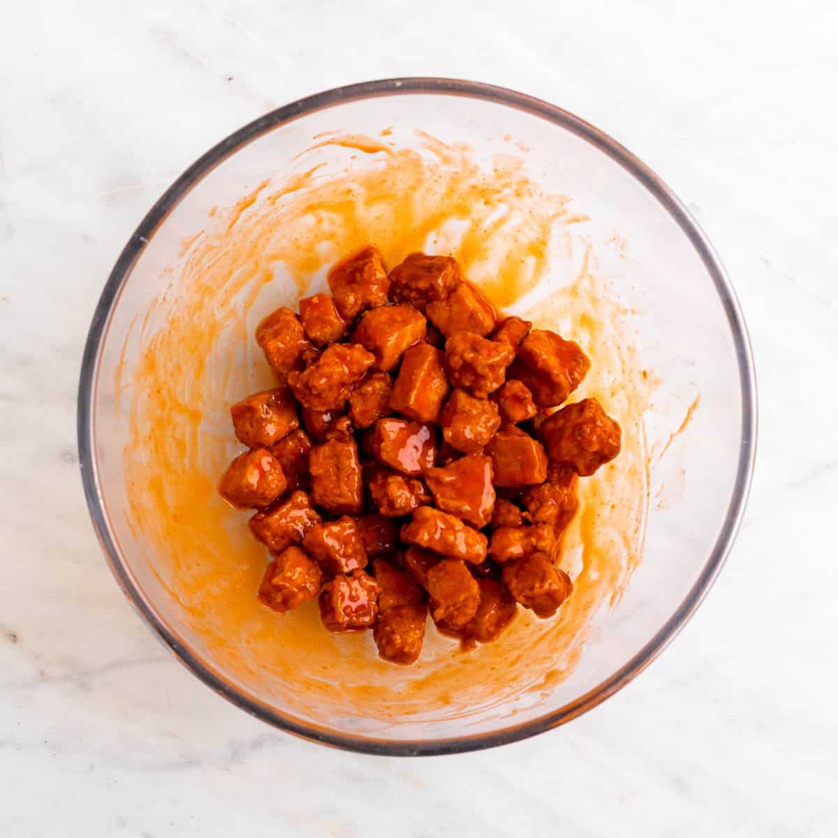 Crispy tofu tossed with buffalo sauce in a bowl