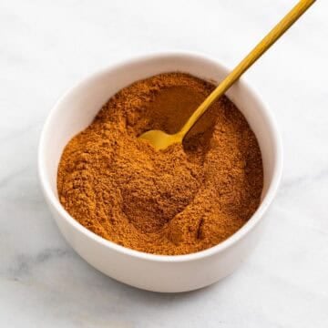 Homemade pumpkin pie spice blend with a gold spoon