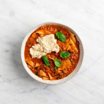 Lasagna soup served in a bowl with vegan ricotta and basil