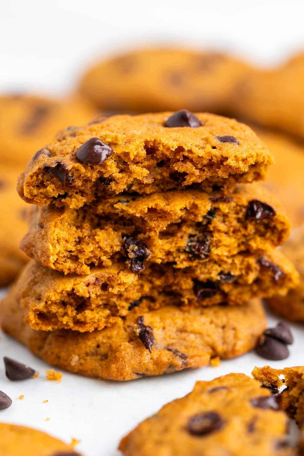 Halved vegan pumpkin chocolate chip cookies stacked on top of each other, showing the centers