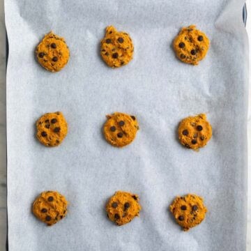 Pumpkin cookie dough portions on lined baking sheets