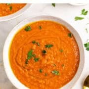 Two bowls of creamy red lentil soup ready to serve