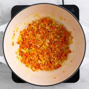Garlic, onion, and carrots cooking in a pot
