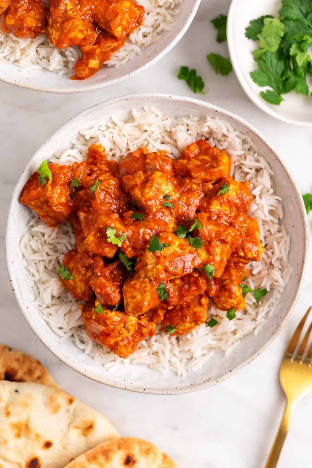 Bowl of tofu tikka masala with basmati rice and pita bread