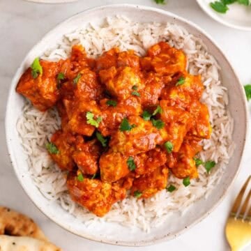 Tofu tikka masala over fluffy basmati rice with pita bread on the side