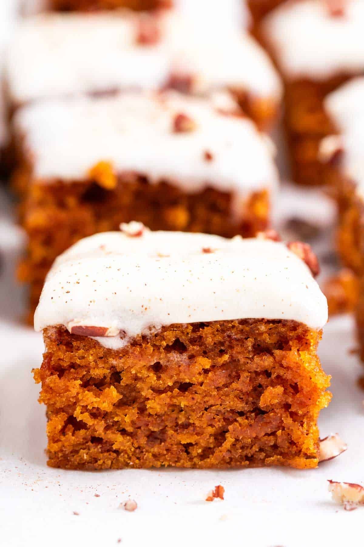 Vegan pumpkin bars topped with chopped pecans and cinnamon