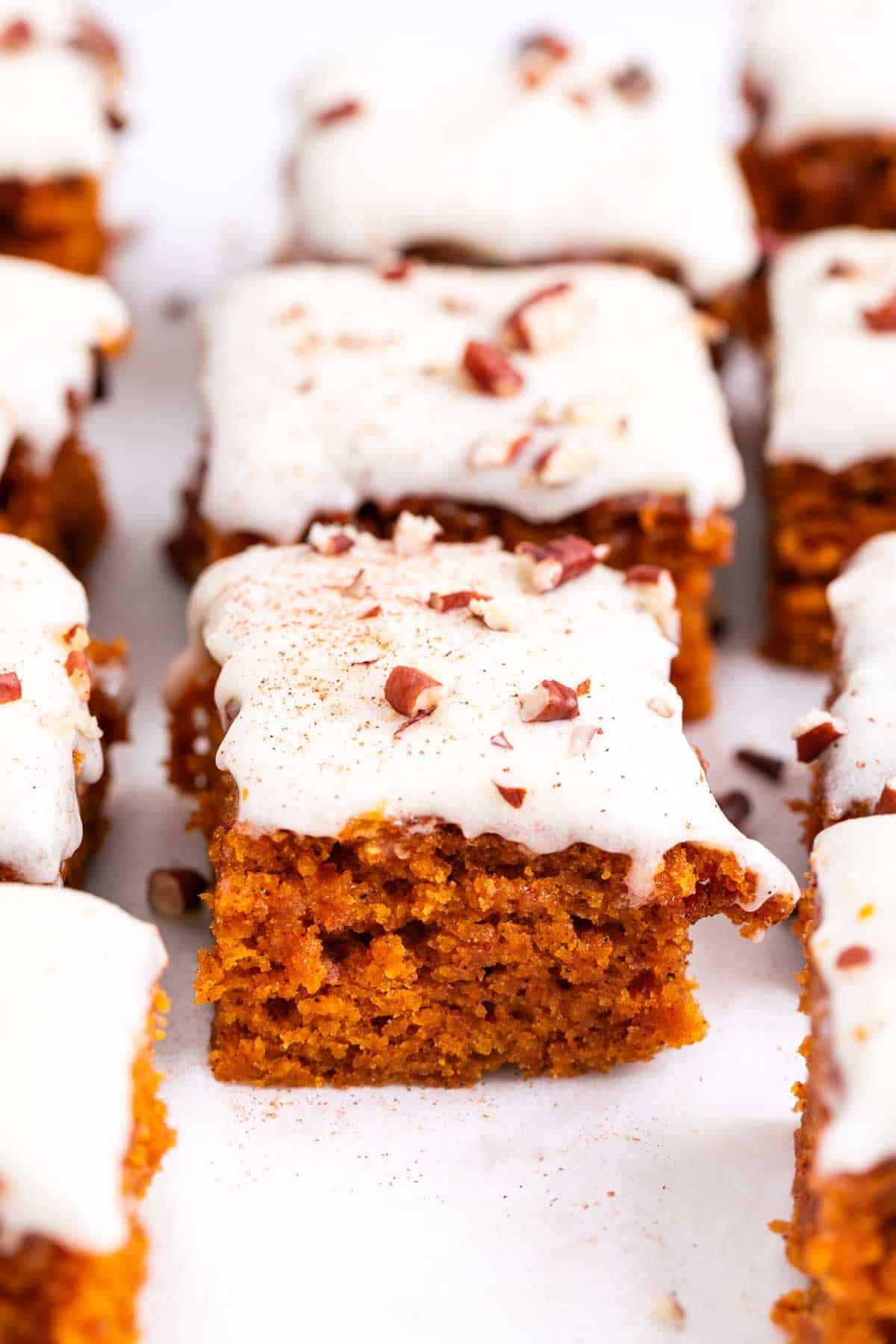 Vegan pumpkin bars with chopped pecans and a sprinkle of cinnamon