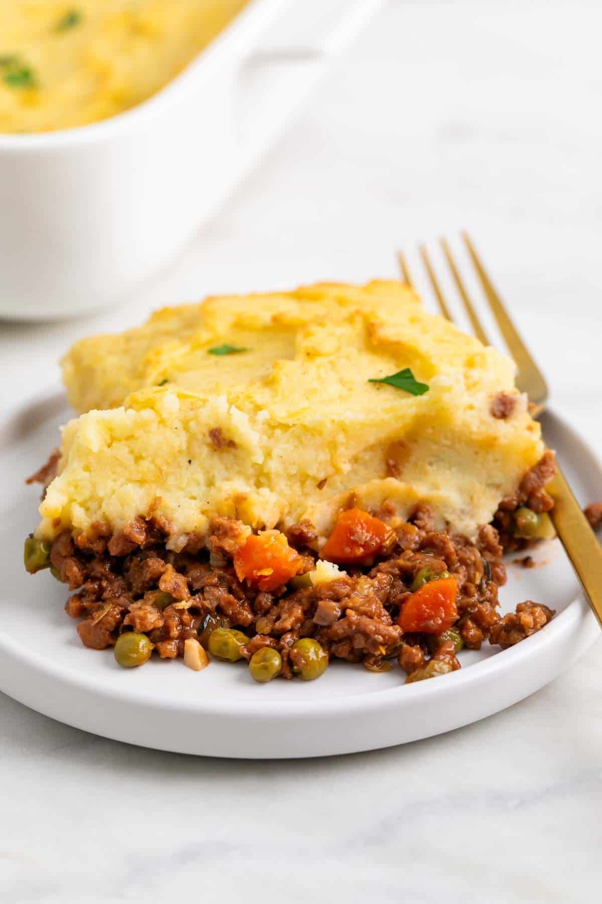 Slice of vegan Shepherd’s pie served on a plate with a fork